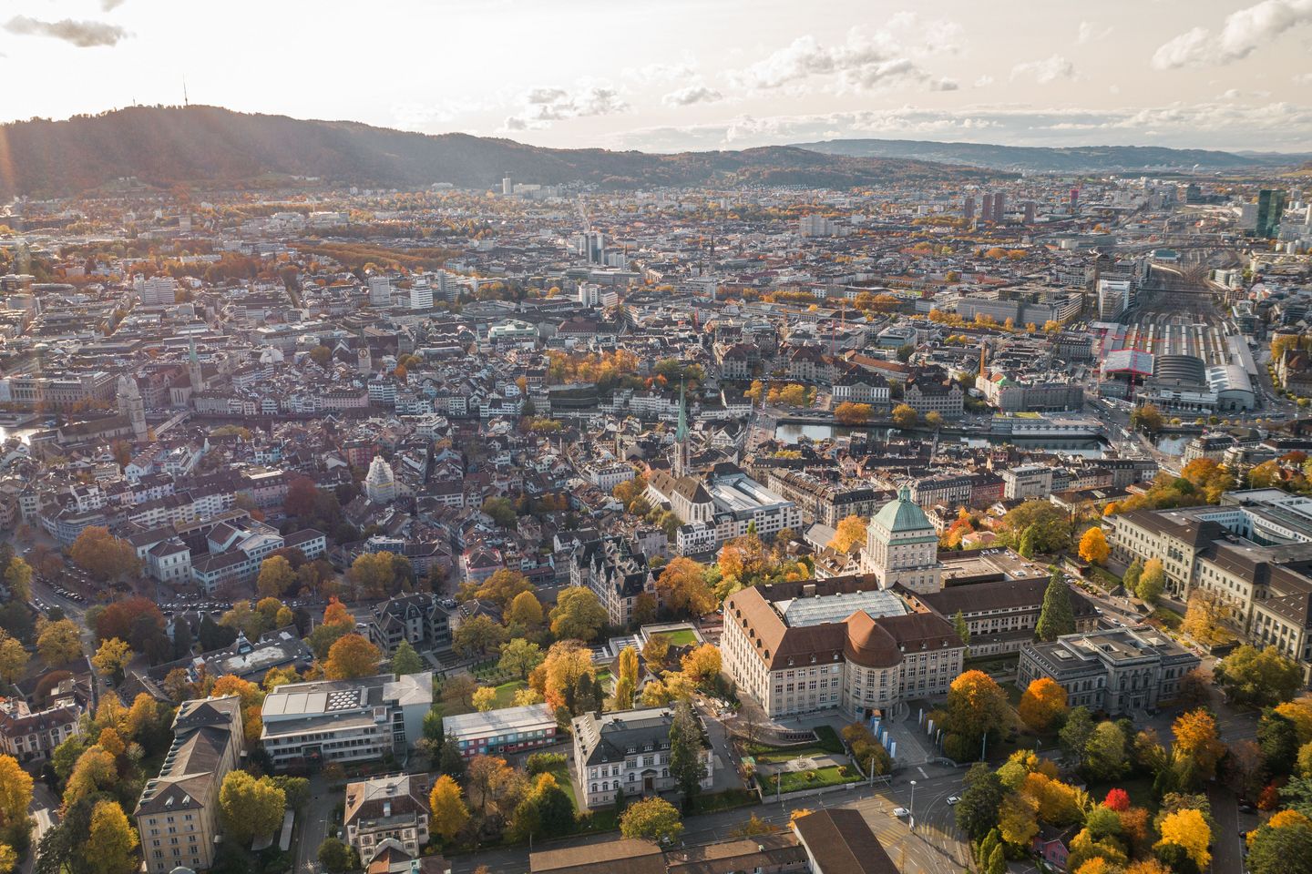 Eine Luftaufnahme von Zürich in Richtung Uetliberg mit der Universität Zürich im vorderen Teil des Bildes.